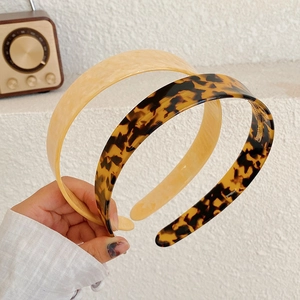 Close-up of minimalist tortoiseshell and cream acetate headbands with smooth finish