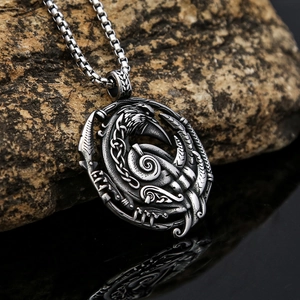 Nordic Viking crow pendant necklace in silver stainless steel on dark stone background