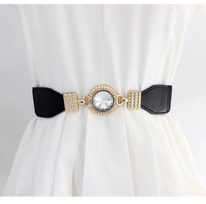 Detail of black elastic waist belt with gold crystal buckle on white dress
