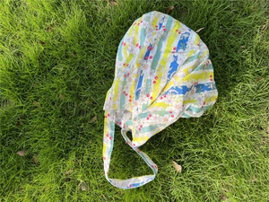 Detailed pattern of floral canvas tote bag with yellow stripes on green lawn