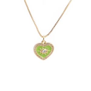 Close-up of gold heart necklace with green enamel, evil eye pattern and crystal inlay
