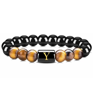Détail du bracelet en perles d'onyx noir, œil de tigre et breloque dorée lettre Y