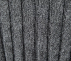 Macro detail of the grey knitted rib fabric showing texture and wool-like fibers