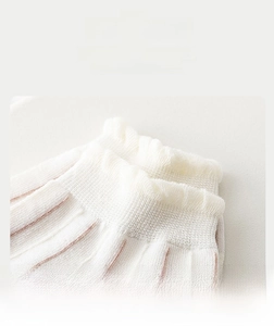Close-up of white ribbed knit cotton socks showing the high-elasticity ankle cuff detail