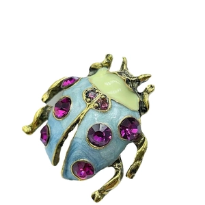 Creative ladybug brooch with blue enamel and purple crystals on a gold alloy base