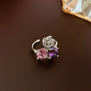 Close-up of silver rose ring featuring pink and purple teardrop zircon stones
