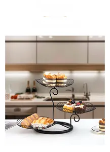 Three-tier black metal wire fruit basket with spiral tiered trays in a modern kitchen