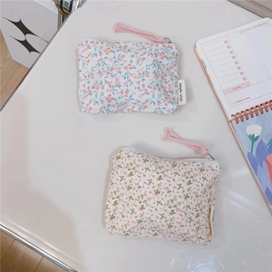 Detailed view of floral cotton mini pouches with zipper closure and brand label