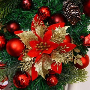 Makrodetail einer roten und goldenen Weihnachtssternblüte auf einem Weihnachtskranz
