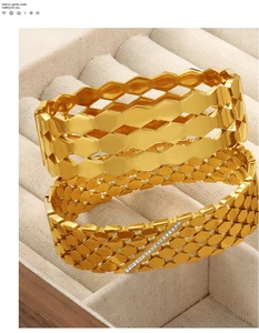 Detail of hollow geometric gold bracelets with honeycomb patterns and zircon inlays