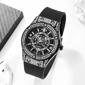 Macro shot of black silicone watch with rhinestones and chronograph dials on white desk