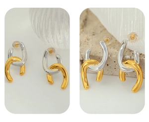Detail of interlocking U-shaped earrings in polished gold and silver metal tones