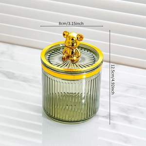 Detailed size view of green glass storage jar with golden teddy bear lid handle