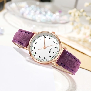 Detail of purple faux leather strap and rose gold quartz watch case with soft floral background