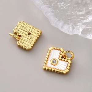 Macro detail of pixel heart charms in 18K gold finish with mother of pearl and zircon