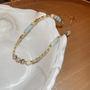 Detailed close-up of mixed beads choker with pearls and cylinder beads on ceramic plate