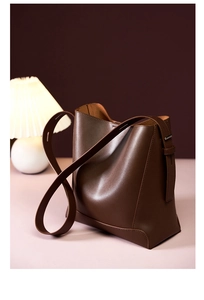 Detail einer dunkelbraunen Leder-Eimertasche mit feinen Nähten und Trageriemen