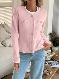 Detail of pink knitted cardigan featuring metallic buttons and decorative chest pockets