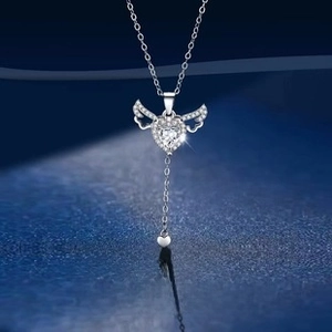 S925 silver heart necklace with moving wings and zircon tassel on blue background