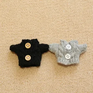 Mini knitted doll sweaters in black and grey with vintage cable knit and button details