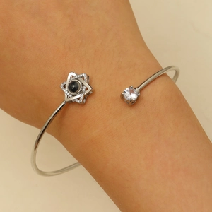 Détail d'un bracelet de projection en argent avec étoile à six branches et pierre de zircon