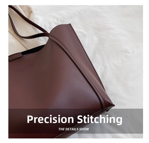Detailed close-up of precise stitching and high-quality dark red leather on tote bag
