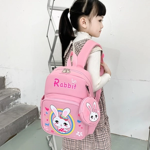 Pink cartoon rabbit backpack for primary students with matching coin purse on a model