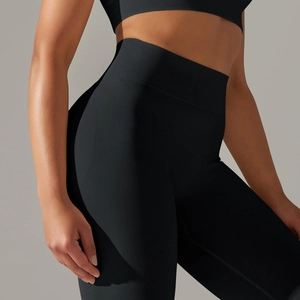 Close-up of black ribbed seamless knit yoga leggings showing waist texture and body curves