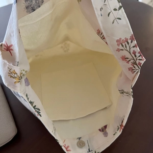 Detail view of the floral cotton bag showing internal pocket and magnetic metal snap closure