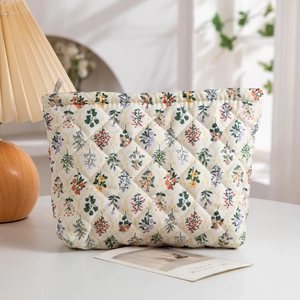 Detailed close-up of floral quilted cosmetic bag featuring soft texture and metal zipper
