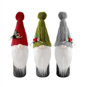Three-piece Christmas gnome wine bottle covers in red, green, and grey knitted fabric