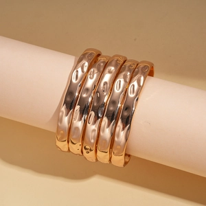 Détail de l'ensemble de 5 bracelets dorés avec texture martelée sur supports design