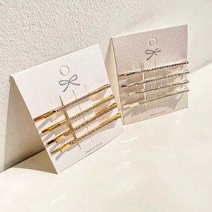 Set of sparkling rhinestone bobby pins in gold and silver finish on display card