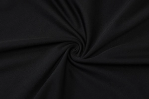 Detailed macro shot of premium black knit fabric with elegant draped folds and texture