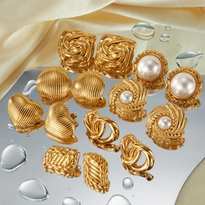 Detailed set of gold plated earrings featuring heart, pearl, and knot designs on satin
