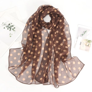Elegante sciarpa in chiffon a pois marroni esposta con riviste di moda minimaliste