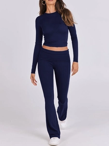 Dettaglio del completo blu scuro con top corto a maniche lunghe e pantaloni a zampa