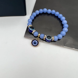 Detail of blue Turkish Evil Eye beaded bracelet with luminous stones and gold charms