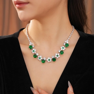 Detail of flower necklace with emerald green crystals and cubic zirconia on a model