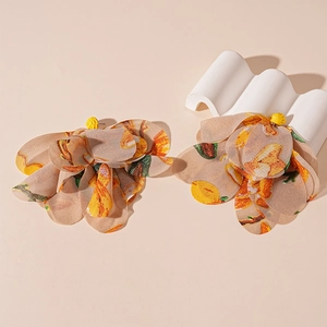 Detailed view of large fabric flower earrings with yellow raffia and petal textures