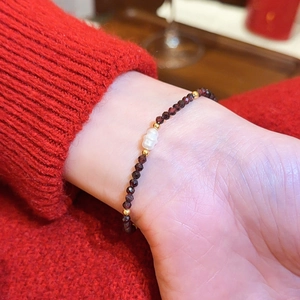 Detailansicht eines roten Achat-Perlenarmbands mit einer zentralen Barockperle als Akzent.
