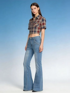 Detail shot of vintage low-rise flared jeans in light blue denim with high-waist slimming fit