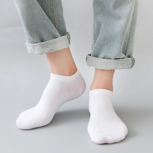 Men and women's white low cut cotton invisible socks with ribbed cuff on light blue jeans