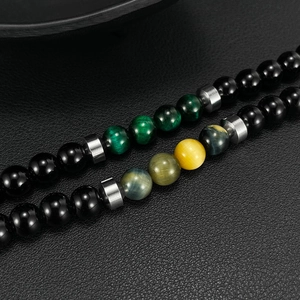 Detailed macro view of men's tiger eye and onyx bead bracelets with metal spacers