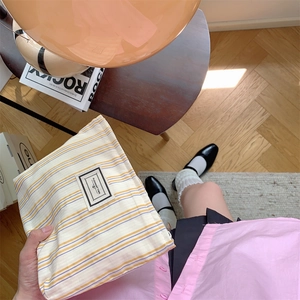 Detail of blue and yellow striped canvas makeup bag with Pleasant Time fabric label