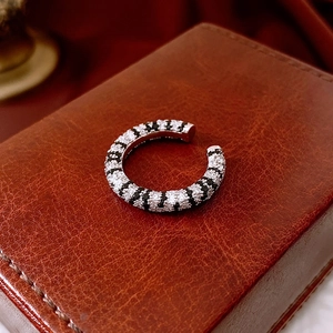 Macro shot of silver C-shape ear cuff with black and white pavé cubic zirconia