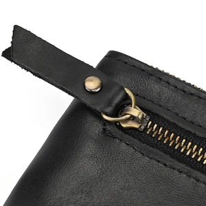 Detailed close-up of premium black leather texture and durable metal zipper on wallet