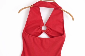 Dettaglio top a collo alto rosso in maglia a coste con anello in metallo lucido