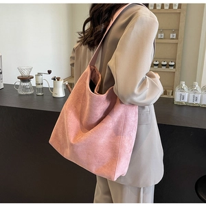 Nahaufnahme der rosa Wildleder-Einkaufstasche mit matter Textur in einem Café-Ambiente