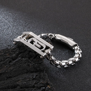 Detail of silver heavy chain bracelet for men with geometric G-link on black rock